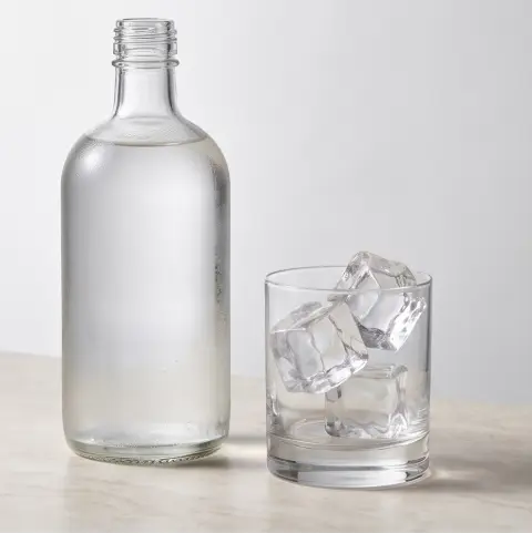 A bottle of craft soju with ice, luxury product photography, minimal composition