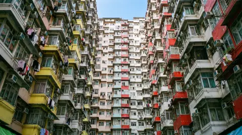 Hong Kong Monster Building courtyard looking up, dense colorful apartment windows with laundry and air conditioners, a s