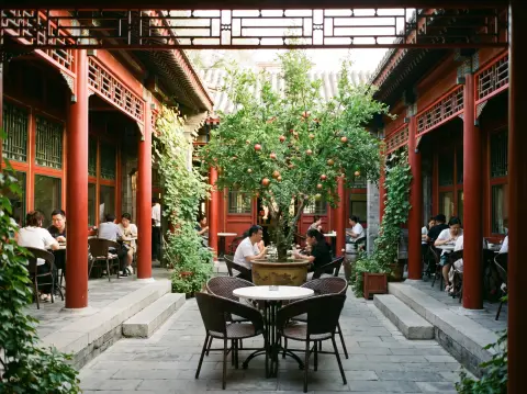 Chinese courtyard house siheyuan converted into a café, red wooden columns, lattice windows, potted pomegranate tree